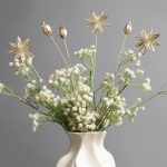 A close-up of Golden Spice Metal Sticks arranged in a vase with white baby’s breath flowers, highlighting their elegant gold finish and unique spice-inspired design.