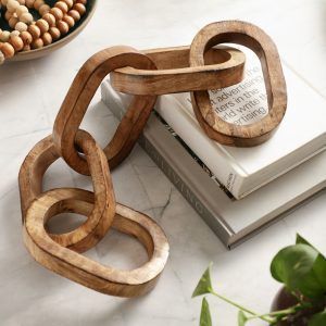 Wooden chain decor with 5 knots in natural finish on books, rustic table accent.