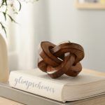 Triple Knot Wooden Accent Piece in natural finish on books, modern home decor.