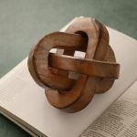 Natural finish Triple Knot Wooden Accent decor styled on open book, artisan piece.
