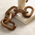 Decorative wooden chain with 5 links on marble table, rustic home decor piece.