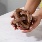Triple Knot Wooden Accent Piece in natural finish held in hands, compact home decor.