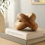 Handcrafted wooden chain with 2 knot sculpture in natural finish displayed on coffee table books.