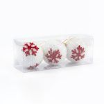 A clear rectangular box containing a set of three white frosted snowball Christmas ornaments with red snowflake accents on a white background.