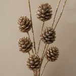 Macro shot of glittered sequin pine cone sticks highlighting the individual sequins and sparkly glitter texture on the branches.