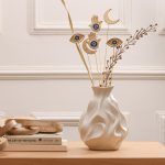 Full decor arrangement featuring the set of 6 golden charm sticks mixed with dried botanical sprigs in a textured white vase.