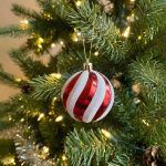 Red and white striped glitter Christmas ornament with candy cane swirl design.