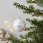 Textured white Christmas ball ornament with sparkling confetti glitter resembling a snowball.