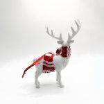 Rear view of the white reindeer ornament, detailing how the red and white knit scarf wraps around the neck and displaying the tail.
