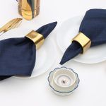 Double place setting featuring Glimpse Homes Golden Cuff Napkin Rings for a modern dining table arrangement with gold accents.