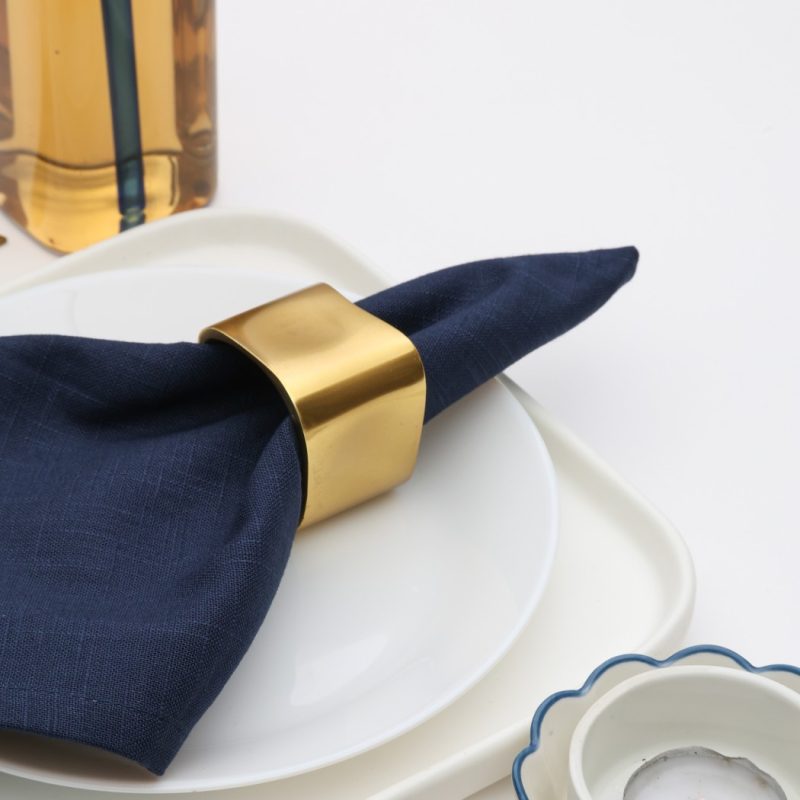 Detailed close-up of the Glimpse Homes Golden Cuff Napkin Ring highlighting the high-quality smooth metal texture and champagne gold tone.