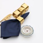 A stack of 4 Glimpse Homes Golden Cuff Napkin Rings displaying the sturdy metal construction, premium weight, and satin finish.