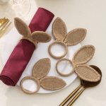 Overhead view of 4 handmade jute rabbit ear napkin rings styled for a rustic farmhouse table decor.