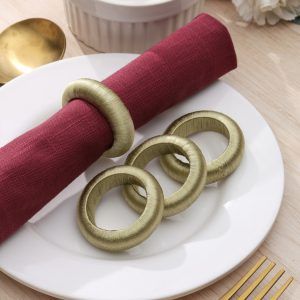 detailed texture view of handmade green yarn napkin rings stacked on a white dinner plate.