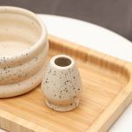 Close-up detail of the ceramic whisk holder stand in matte off-white with black speckles by Glimpse Homes, showing the double-ring shape.