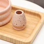 Close-up detail of the Glimpse Homes matte pink ceramic whisk holder with black speckles and a rounded double-ring design.