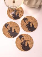 Top view of four Glimpse Homes 4-inch Audrey Hepburn cork coasters stylishly scattered around a cocktail glass on a light background.