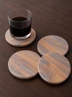 Glimpse Homes highly absorbent natural sandstone coasters protecting a tabletop from a cold, dark beverage.