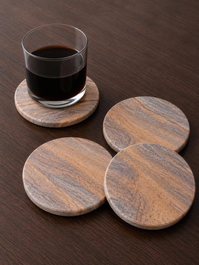 Glimpse Homes highly absorbent natural sandstone coasters protecting a tabletop from a cold, dark beverage.