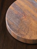 Close-up macro shot revealing the natural porous texture and earthy Desert Swirl pattern of a Glimpse Homes sandstone coaster.