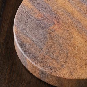 Close-up macro shot revealing the natural porous texture and earthy Desert Swirl pattern of a Glimpse Homes sandstone coaster.