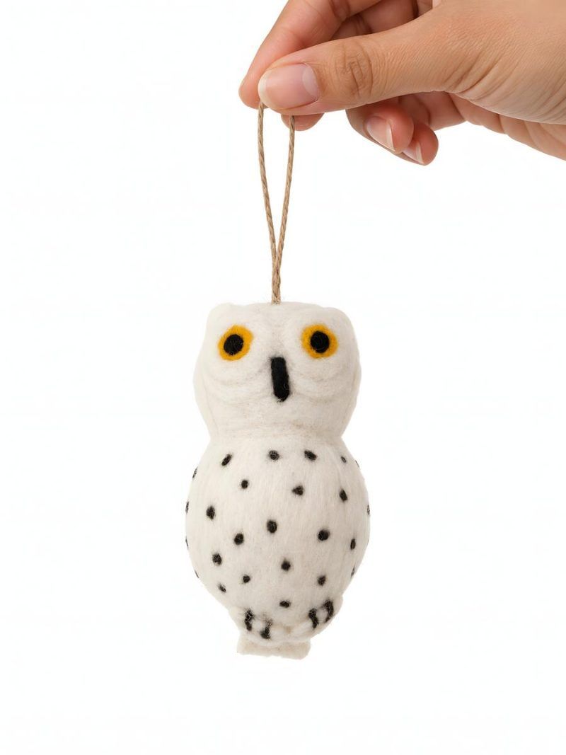 Front view of Glimpse Homes felt snowy owl ornament with orange embroidered eyes and polka dot body