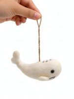 Glimpse Homes felt white whale ornament with embroidered eyes and tail, held by hand