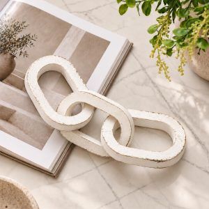 3 Knot Long Wooden Chain in Vintage White Finish styled on marble table with greenery.