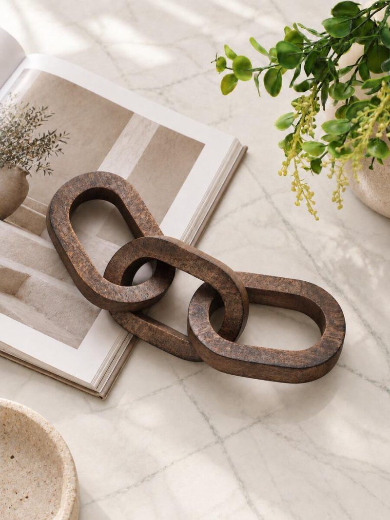 3 Knot Long Wooden Chain in Walnut Finish styled on marble table with greenery.
