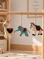 Glimpse Homes felt llama, elephant and horse ornaments hanging on a wooden mobile in a kids' nursery room