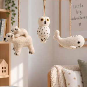 Glimpse Homes felt polar bear, owl and whale ornaments hanging on a wooden mobile in a kids' nursery room