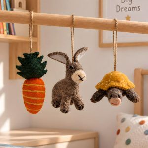 Glimpse Homes felt rabbit, tortoise and carrot ornaments hanging in a kids nursery room