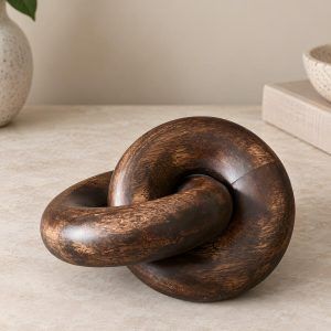 Close-up of Glimpse Homes walnut finish wooden knot chain decor showing rich wood grain texture.