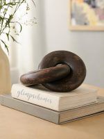 Glimpse Homes walnut finish wooden knot chain decor piece displayed on stacked books.