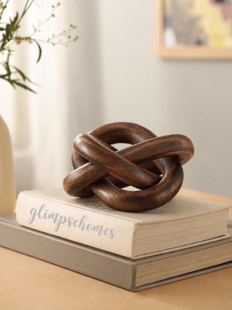 Glimpse Homes decorative wooden knot chain in walnut finish placed on books as tabletop decor